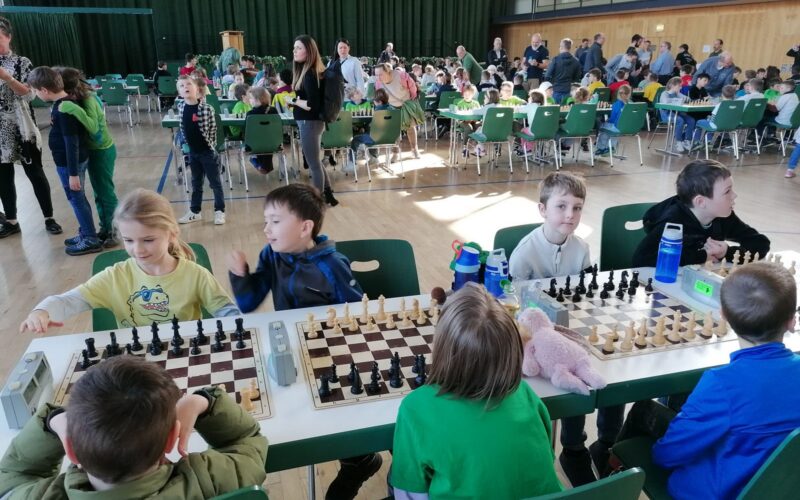 Kinder spielen Schach in einer großen Halle